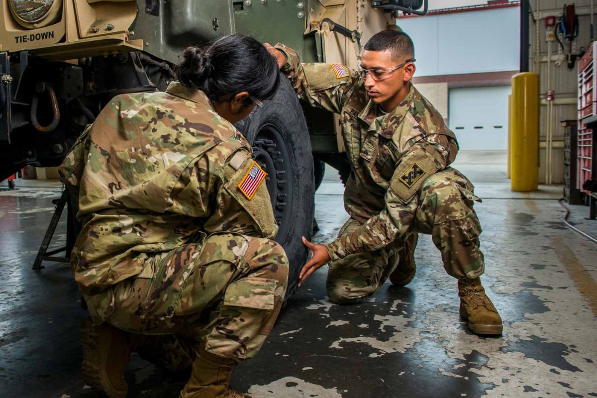 two children hug a service member
